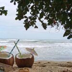 Costa Rica e Pura Vida: due noci di cocco aperte, fedi nuziali e un biglietto sulla sabbia del Caribe sud.