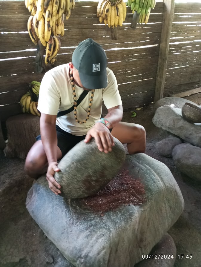 Robert, guida in Costa Rica, mostra la lavorazione del cacao su pietra. Un momento autentico e Pura Vida durante il tour.
