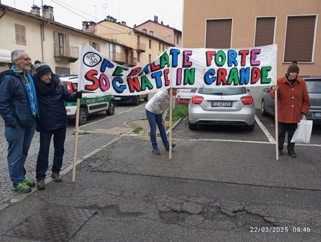 Persone con striscione motivazionale, pedalando oltre i limiti tra sogni e sport in un'atmosfera di comunità e gioia.