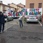 Persone con striscione motivazionale, pedalando oltre i limiti tra sogni e sport in un'atmosfera di comunità e gioia.