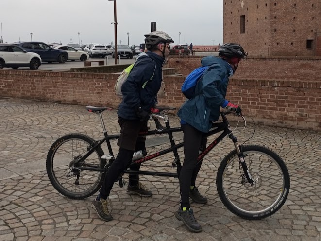 Gemini ha detto
Alessandro e Pier scendono dal tandem durante una sosta, pedalando oltre i limiti con equilibrio e intesa.