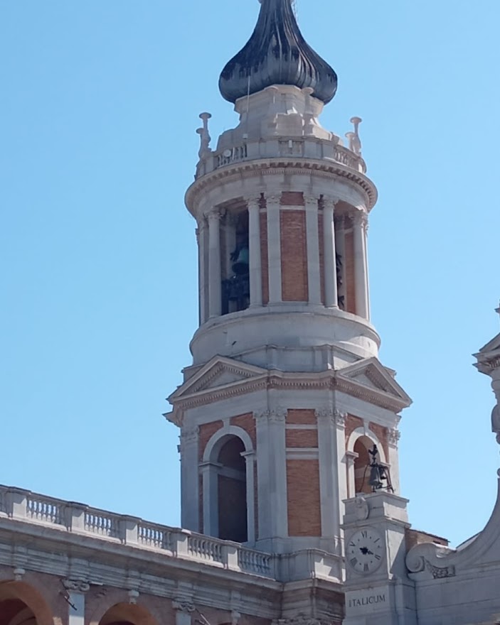 Loreto un luogo antico che parla al cuore: l'elegante campanile del Vanvitelli svetta contro il cielo azzurro terso.