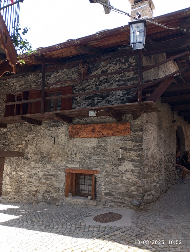 Chianale la gemma alpina della Val Varaita, casa in pietra con balcone in legno nel borgo storico di montagna.