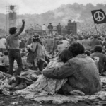 Immagine: Foto reportage in bianco e nero di un festival anni Sessanta: folla pacifica su un prato, musica, libertà, comunità e spirito di cambiamento collettivo. Woodstock 3 giorni di pace amore e musica
