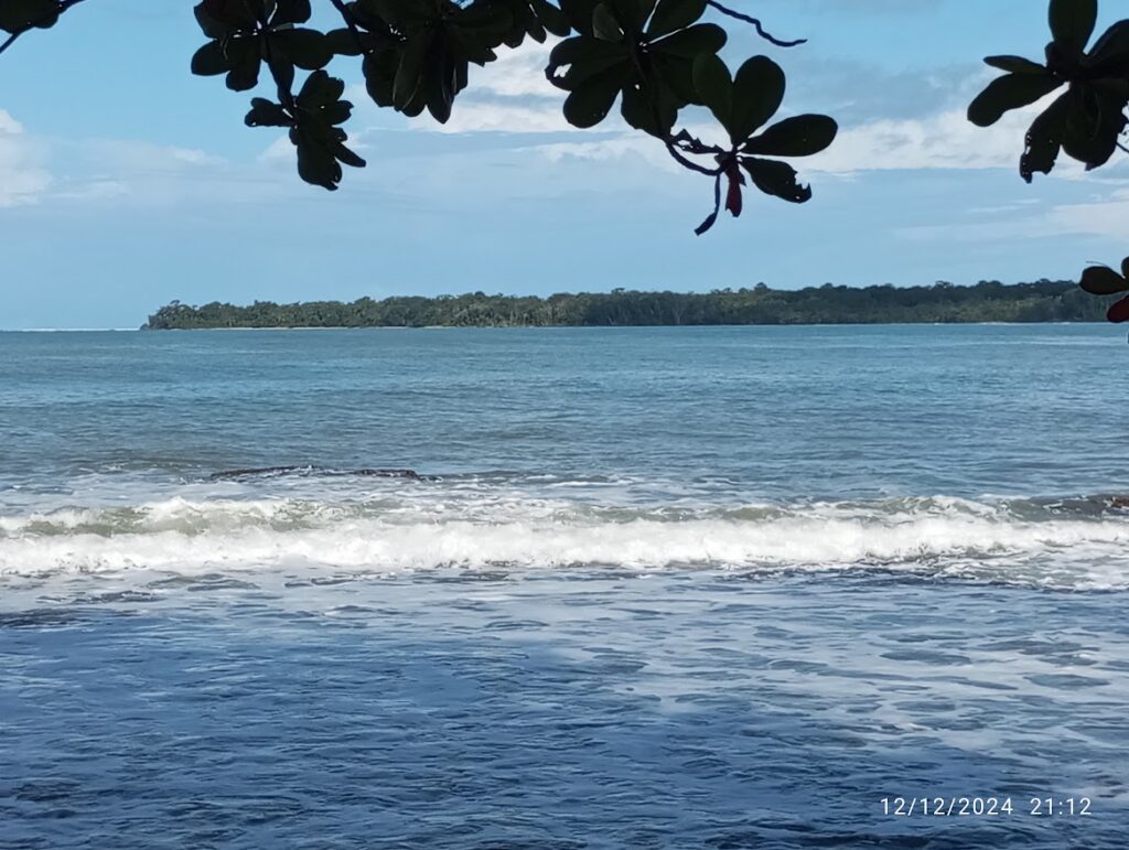 Immagine: In pirmo pian l'oceano Atlantico visto da Playa Chiquita. Sullo sfondo la penisola cn la vegetazione fino alla spiaggia