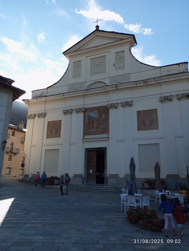 Foto:Facciata della chiesa nel centro di La Salle, affreschi religiosi, ingresso aperto sulla piazza con persone e tavolini all’aperto, cose da fare a La Salle