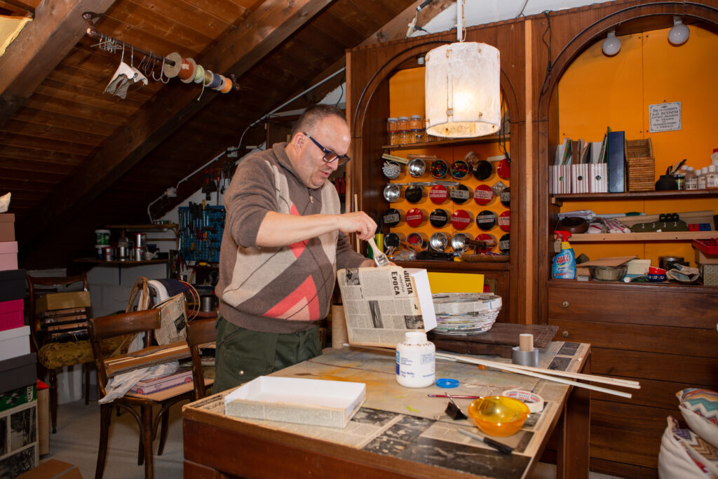 Luca Laganà al lavoro nel suo laboratorio mentre realizza un’opera di riciclo creativo con materiali di recupero.